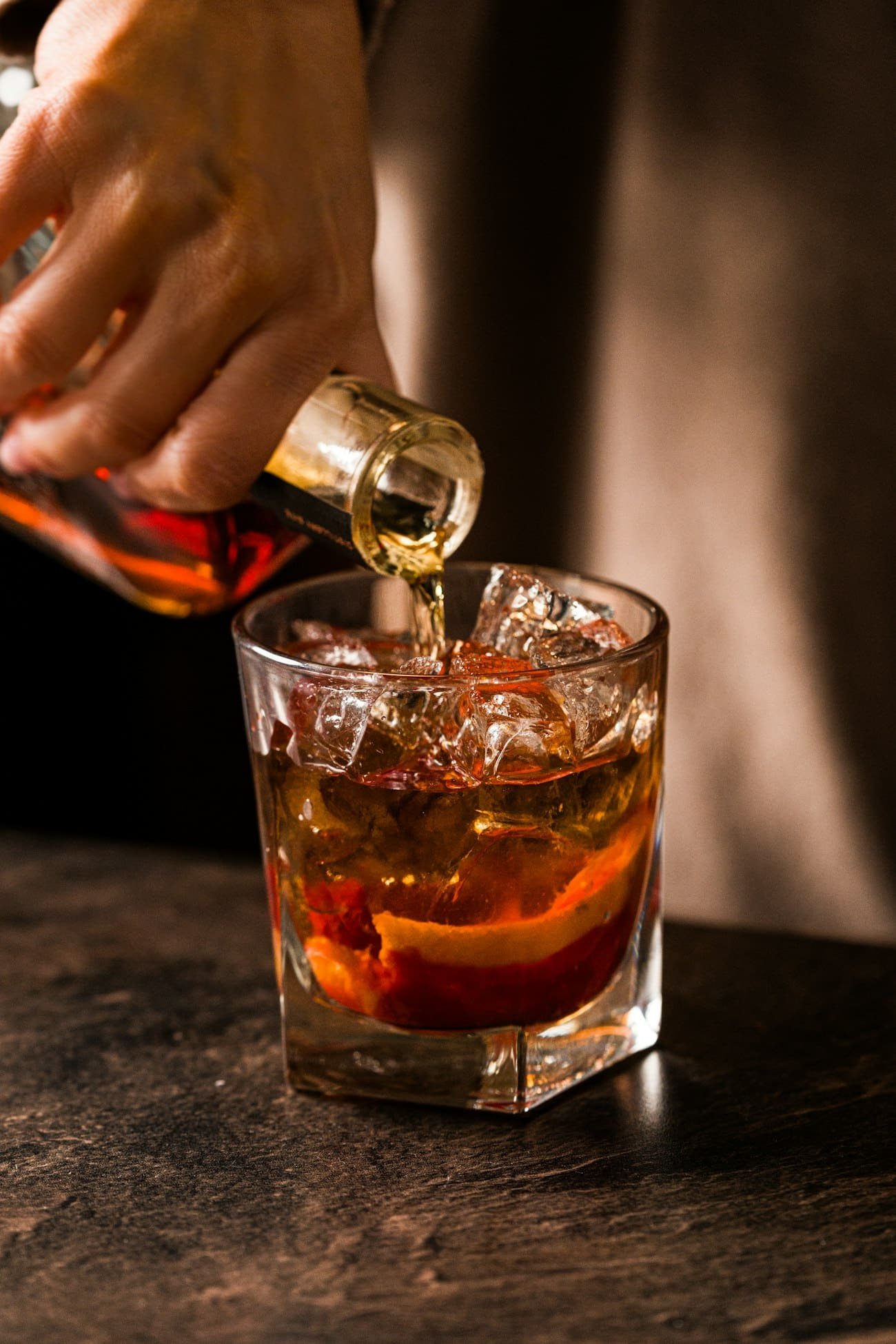 Barman sirviendo un destilado sobre hielo