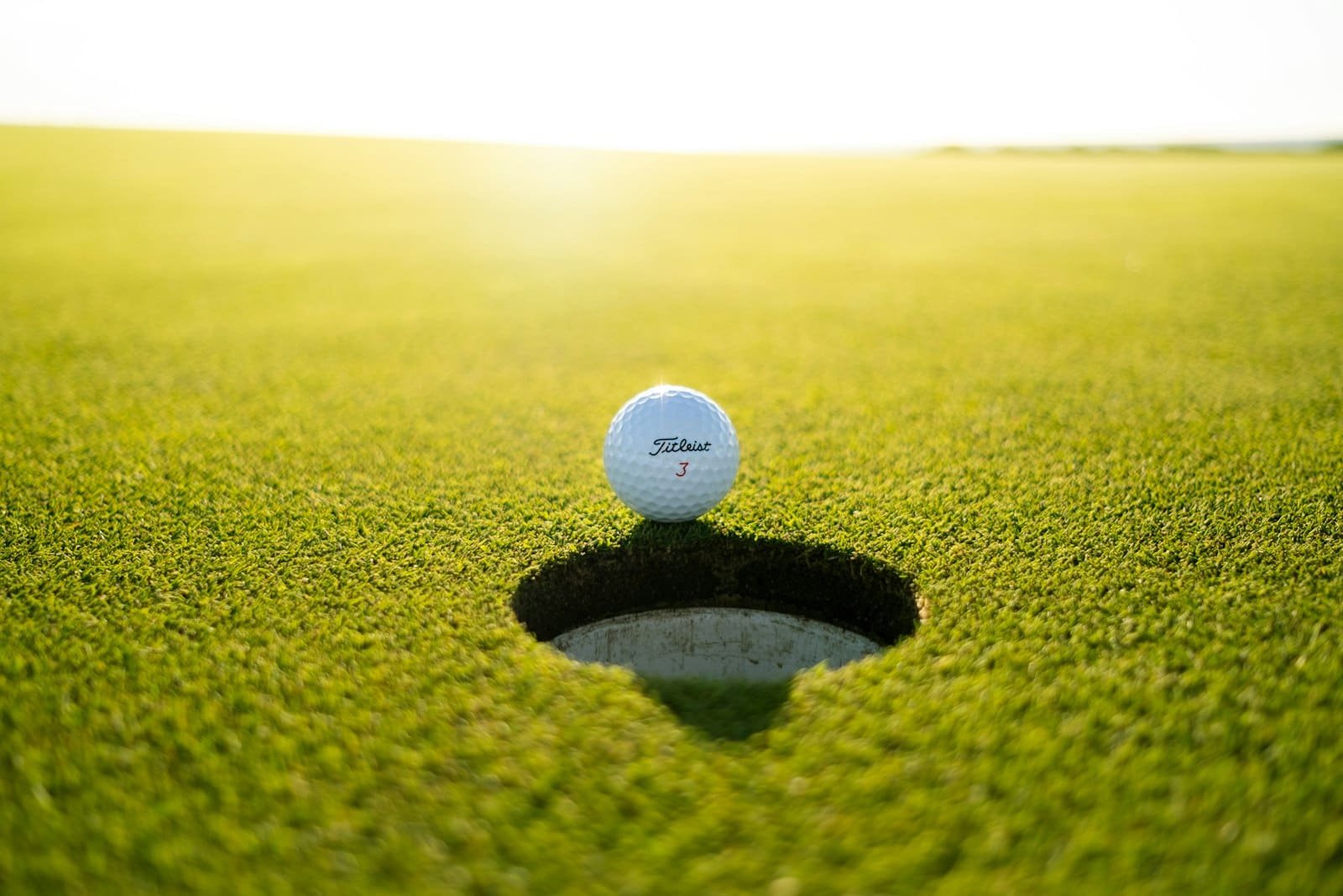 Bola de golf al borde del hoyo